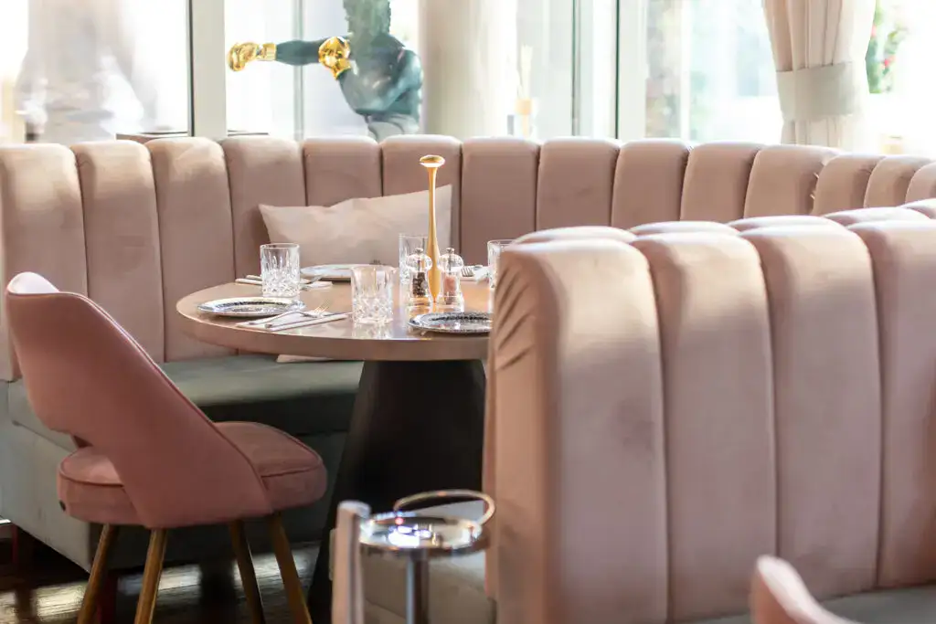 Stylischer moderner Restaurantbereich mit eleganten Banketts, edlen Stühlen, stilvollem Dekor und viel natürlichem Licht, perfekt für modernes Dining mit Design-Atmosphäre.