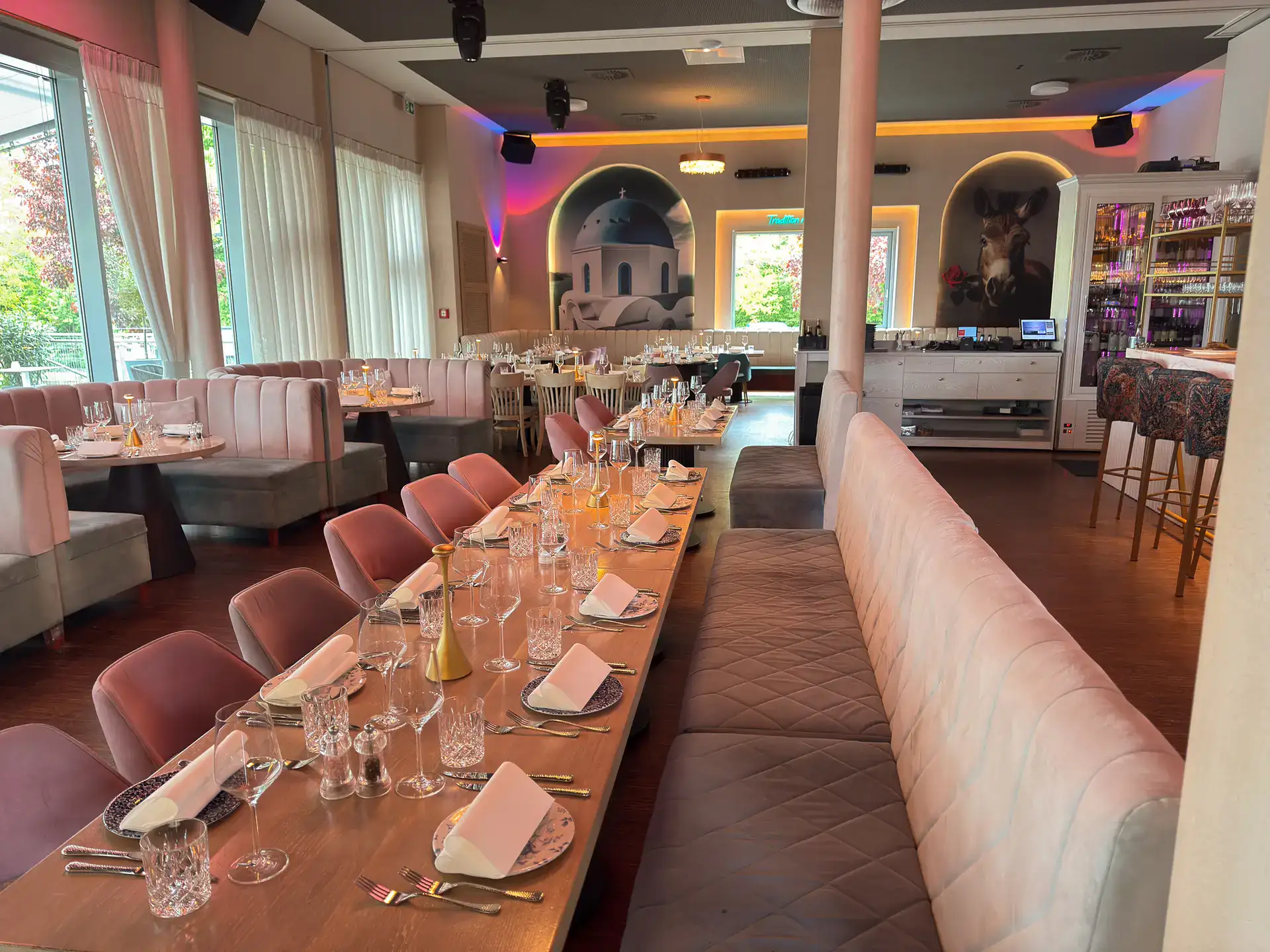 Moderne, elegante Restaurantgestaltung mit gemütlicher Atmosphäre, stilvollem Mobiliar und stimmungsvoller Beleuchtung, ideal für Events und Feiern im mediterranen Stil.